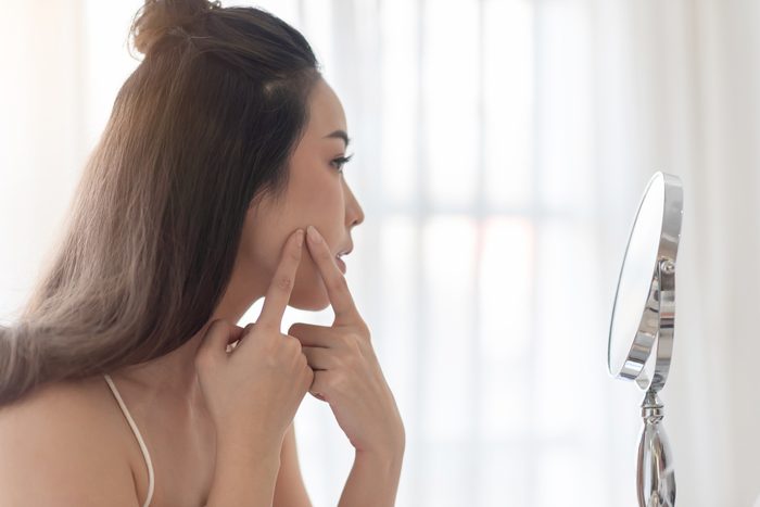 woman popping pimple