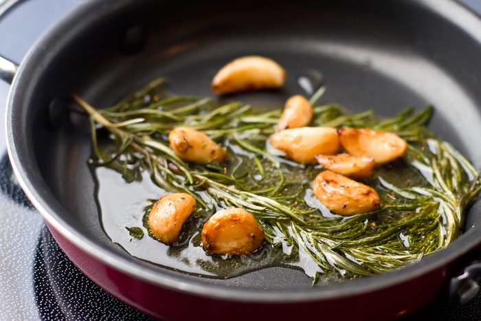 garlic and rosemary cooking in olive oil