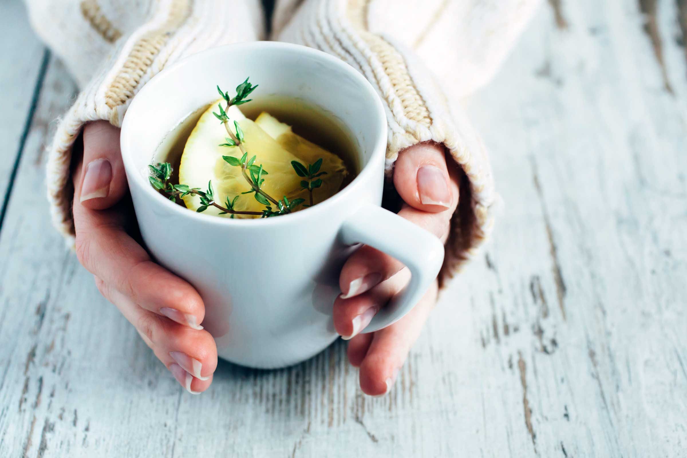 hands clasp big mug of tea