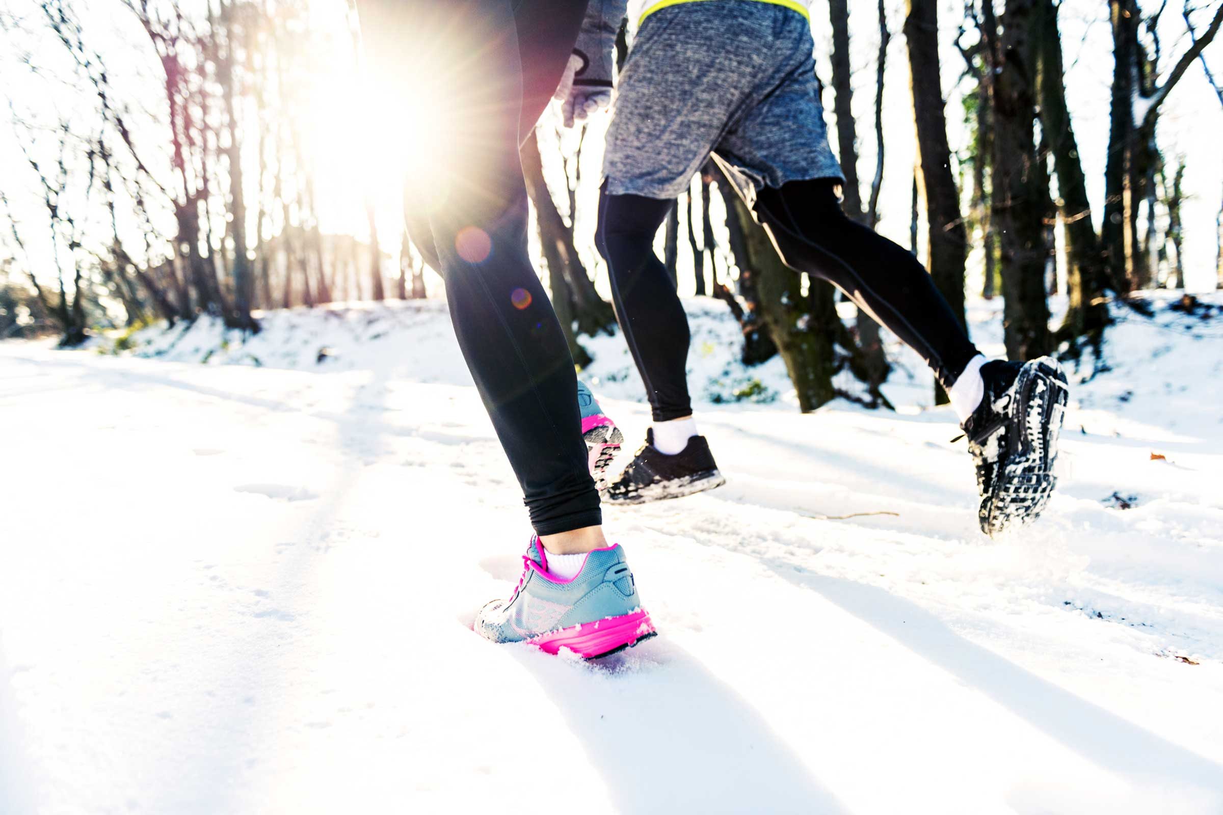 runners' feet in snowy woods