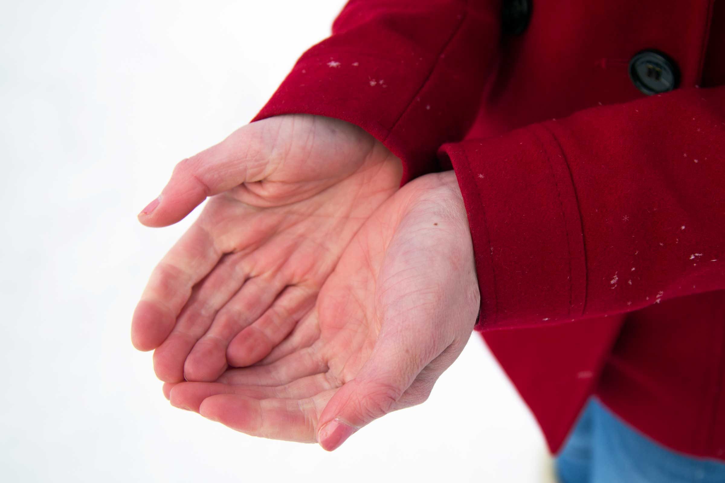 Man cups hands in snow