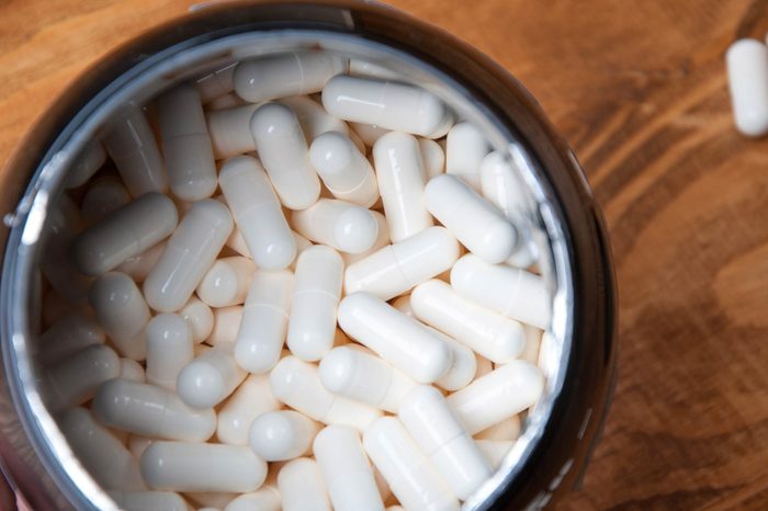 container full of white pill capsules 