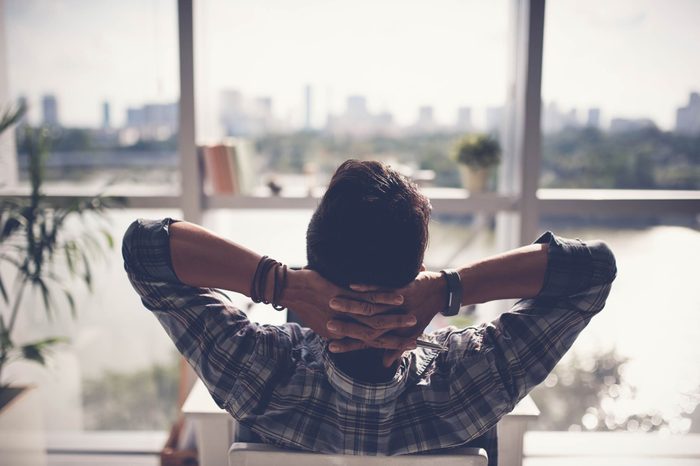 man relaxing in chair, hand behinds head