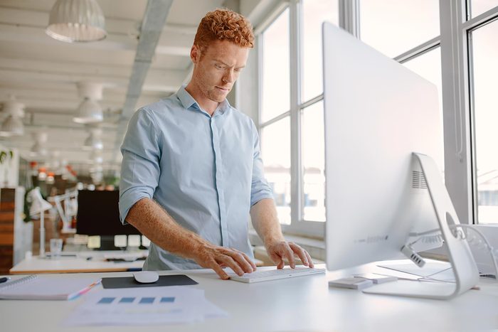 man standing at computer
