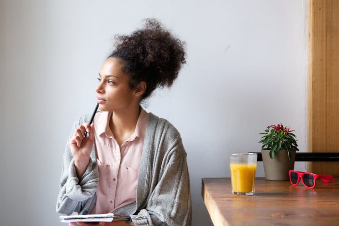 Woman with notepad and pen sitting at a table