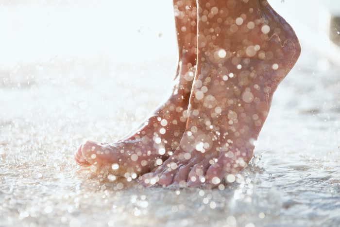 Feet under shower outdoors