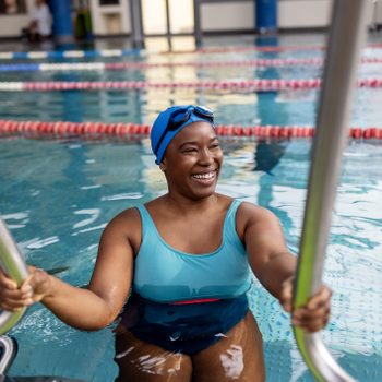 Smiling Woman Swimmer Entering Pool